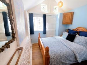 a bedroom with a bed with blue walls and a mirror at 4 Bed in Godshill oc-ic034 in Godshill