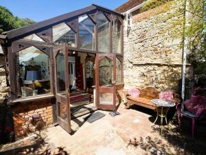 a glassconservatory in a stone house with a bench at 4 Bed in Godshill oc-ic034 in Godshill