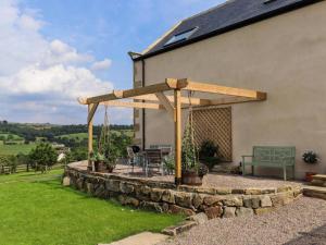 a wooden pergola with a table and a bench at 2 Bed in Harrogate oc-75642 in Summer Bridge
