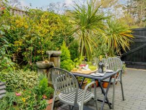a table and chairs in a garden with plants at 1 Bed in Christchurch oc-90444 in Highcliffe