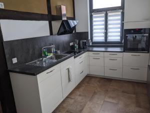 a kitchen with white cabinets and a black counter top at Wohnung Burgstraße in Wittenberge