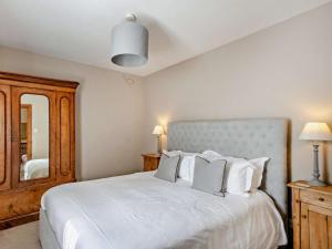 a bedroom with a large white bed and a mirror at 1 Bed in York oc-84002 in Crayke