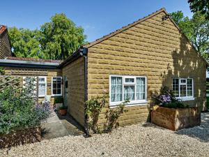 a brick house with white windows and a yard at 1 Bed in York oc-84002 in Crayke