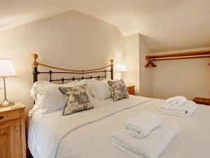 a bedroom with a large white bed with towels on it at 4 Bed in Frome oc-27808 in Holwell