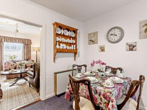a dining room with a table and a clock on the wall at 2 Bed in Consett oc-92807 in Hunstanworth +11 photos