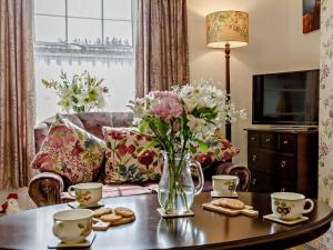 a living room with a vase of flowers on a table at 2 Bed in Consett oc-92807 in Hunstanworth