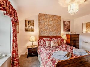 a bedroom with a bed with a red bedspread at 2 Bed in Consett oc-92807 in Hunstanworth