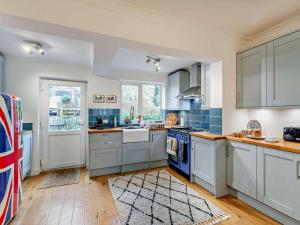a kitchen with white cabinets and blue tiles at 3 Bed in Ripon oc-94477 in Ripon +13 photos