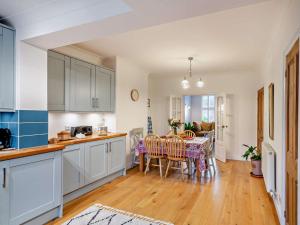 a kitchen with white cabinets and a table with chairs at 3 Bed in Ripon oc-94477 in Ripon