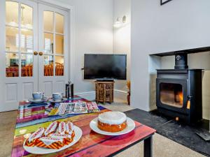 a living room with a table with a cake and a stove at 3 Bed in Ripon oc-94477 in Ripon