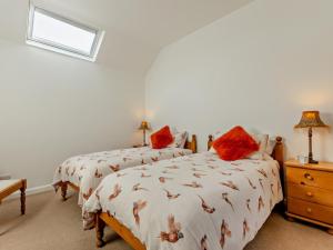 a bedroom with two beds with red pillows at 2 Bed in Driffield oc-79280 in Wold Newton
