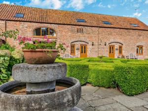 a stone fountain in front of a brick house at 2 Bed in Driffield oc-79280 in Wold Newton