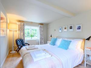 a bedroom with a large white bed with blue pillows at 1 Bed in Brockenhurst oc-78926 in Beaulieu