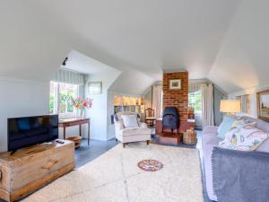 a living room with a couch and a tv and a fireplace at 1 Bed in Brockenhurst oc-78926 in Beaulieu
