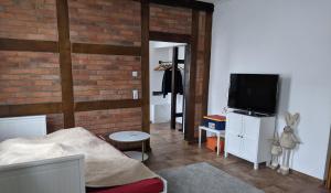 a living room with a brick wall and a television at Wohnung Burgstraße in Wittenberge