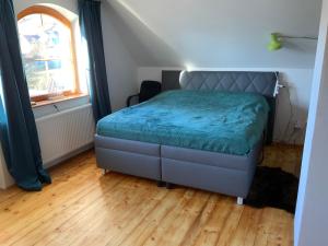 a bedroom with a bed with a blue comforter and a window at Hunters Lodge in Liptovská Lúžna +18 photos
