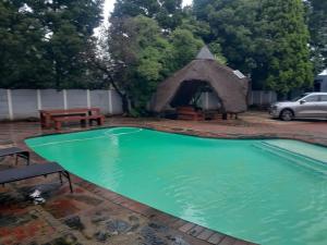 a swimming pool with a gazebo in a yard at B&P Guesthouse in Boksburg