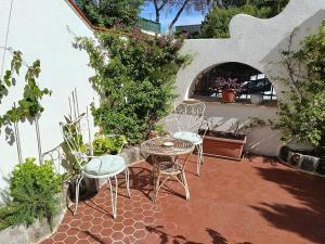 a patio with a table and chairs and plants at Villetta Ninì in Ischia Town