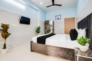 a bedroom with a bed and a tv on a wall at Hotel O Safe & Sure Residency in Gurgaon