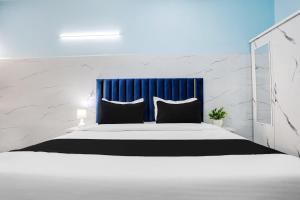 a bedroom with a large bed with a blue curtain at Hotel O Safe & Sure Residency in Gurgaon +33 photos