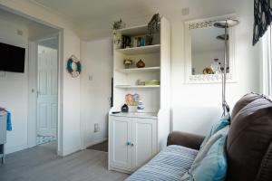 a living room with a couch and a mirror at Chalet 80 in Sandown