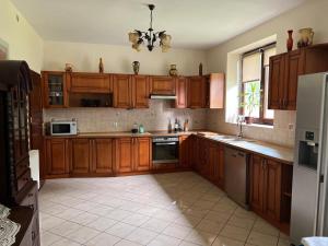 a kitchen with wooden cabinets and a refrigerator at Dom Acapulco in Kromszewice