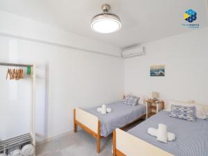 two beds in a room with white walls at Can Tassi in Porto Cristo