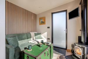 a living room with a green couch and a stove at 1 Bed in Austwick oc-b37509 in Austwick