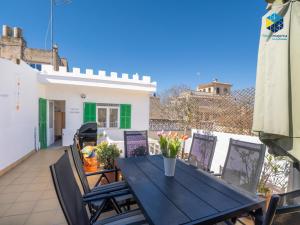 a black table and chairs on the balcony of a house at Can Tassi in Porto Cristo