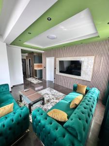 a living room with a green couch and a tv at Cataleya III in Sarajevo