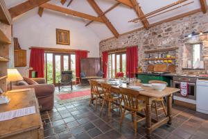 a kitchen and living room with a table and chairs at Crabhall Barn in Haverfordwest