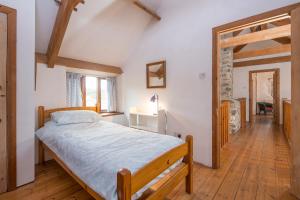 a bedroom with a bed and a wooden floor at Crabhall Barn in Haverfordwest