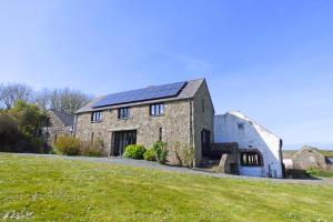 an old stone house with solar panels on it at Crabhall Barn in Haverfordwest