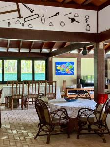 a dining room with a table and chairs at Casa Jataí Guest House in Barra do Sahy