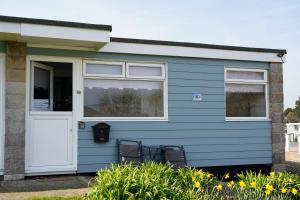 a blue house with a white door and windows at Chalet 80 in Sandown