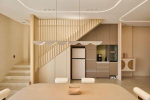a room with a staircase and a table and chairs at 藤夏日光 in Weiqian