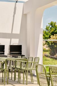 a row of green chairs and tables on a patio at 藤夏日光 in Weiqian