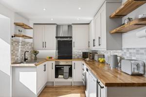 a kitchen with white cabinets and wooden counter tops at 2 Bed in Aberystwyth oc-c36918 in Aberystwyth