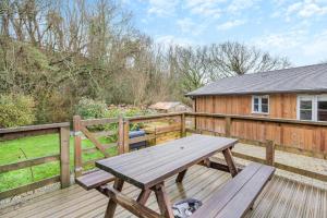 a wooden deck with a picnic table on a fence at 3 Bed in Winnards Perch oc-m30557 in Saint Columb Major