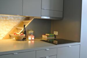 a kitchen with a counter with a bowl of fruit and a bottle of wine at De Buur Van Beer in Ieper
