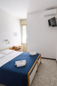 a bedroom with a bed with two towels on it at Camere Capinera in Cesenatico +9 photos