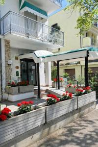 a building with a garden with flowers in front of it at Camere Capinera in Cesenatico