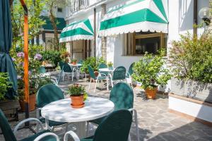 an outdoor patio with tables and chairs and plants at Camere Capinera in Cesenatico