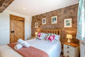 a bedroom with two beds and a stone wall at 3 Bed in Scaleby oc-b33069 in Scaleby