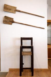 a chair sitting in front of a wall with two axes at Casa Rural Las Camilas- Sierra de Alcaraz in Vianos