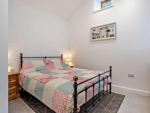 a bedroom with a bed with a quilt on it at 1 Bed in Pickering oc-96309 in Allerston