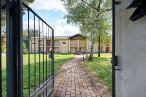 an open door to a building with a brick path at Residence La Brughiera Malpensa in Lonate Pozzolo