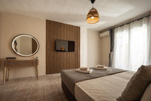 a bedroom with a bed and a mirror at Aggire Summer Suites in Alikanas +23 photos