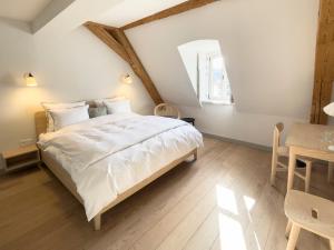 a bedroom with a large white bed and a table at Hotel Josef im Kloster Beuerberg in Eurasburg +32 photos