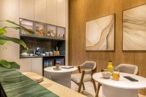 a dining room with two tables and chairs at WELL Residences - By AVA Rentals in Asunción +32 photos